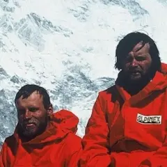 Maciej Berbeka y otro alpinista con chaquetas rojas en un paisaje nevado.