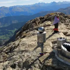 En la cima de una montaña, un monumento con forma de castillo y un poste con una esfera metálica. Al fondo, un valle verde y montañas azules. El **erregeen mahaia** es un lugar de ensueño.