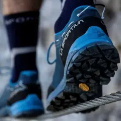 Persona cruza un cable con zapatillas de aproximación La Sportiva, ideales para terrenos difíciles.