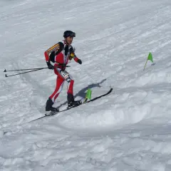 Agustí Roc, esquiador de montaña, compite en una carrera con esquís y bastones, marcado por banderas verdes en la nieve.