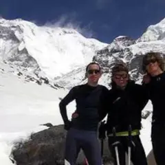 Tres montañistas posan sonrientes ante un imponente pico nevado. Un recuerdo de expedición, antes del iñaki ochoa de olza fallecimiento.