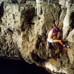 Patrick Edlinger, escalando en solitario una pared rocosa sobre el mar.