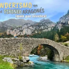 Puente de piedra sobre río turquesa en el Pirineo Aragonés, España. Senderismo entre montañas y bosques otoñales.