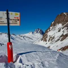 Señalización en la estación de esquí de Formigal, indicando pistas y servicios. Montañas nevadas y cielo azul.
