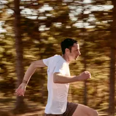 Kilian Jornet corre a toda velocidad en un bosque, capturando la esencia de su último récord.