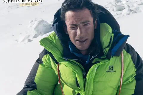 Kilian Jornet, con su chaqueta verde brillante, guiña un ojo en la cima del Everest.