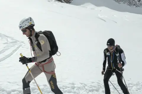 Benjamin Vedrines y otro alpinista ascienden una ladera nevada con equipo de esquí de travesía.