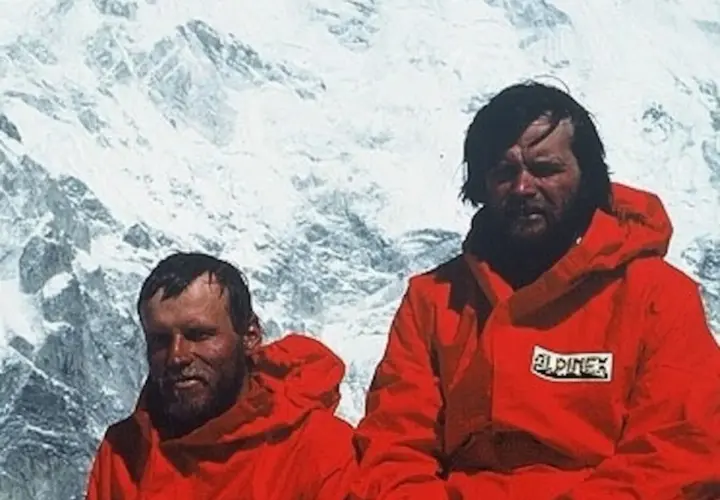 Maciej Berbeka y otro alpinista con chaquetas rojas en un paisaje nevado.