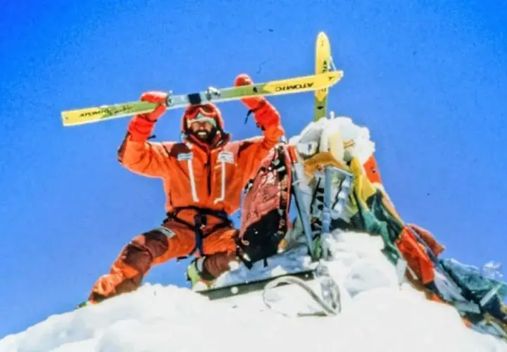 Hans Kammerlander, con esquís, celebra en la cima nevada.