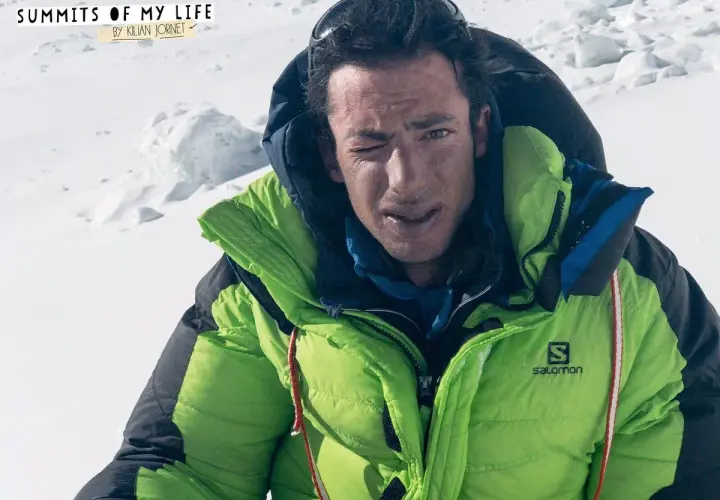 Kilian Jornet, con su chaqueta verde brillante, guiña un ojo en la cima del Everest.