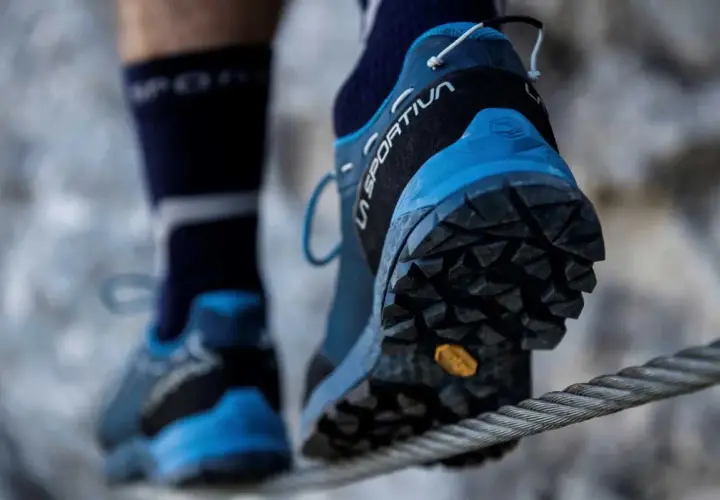 Persona cruza un cable con zapatillas de aproximación La Sportiva, ideales para terrenos difíciles.
