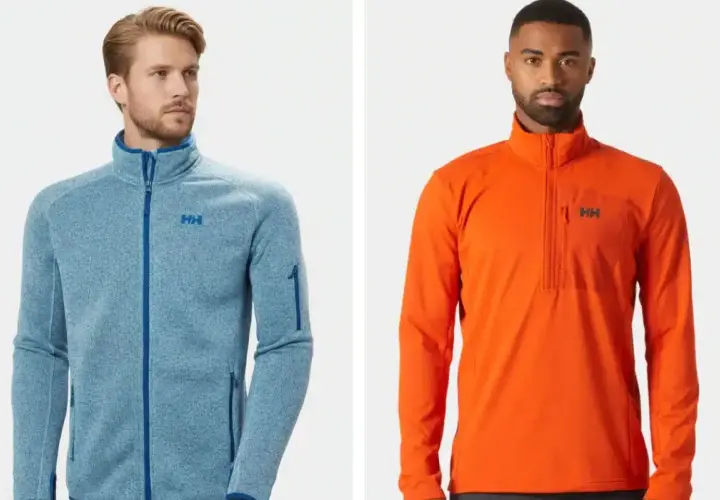 Dos hombres posan con chaquetas Helly Hansen. La de la izquierda es azul jaspeado con cremallera completa, ideal como capa intermedia. La de la derecha es naranja con media cremallera.