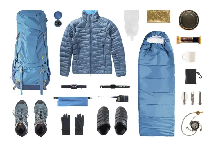 Equipo completo de **material alpinismo**: mochila, saco de dormir, chaqueta, botas, guantes, brújula, linterna frontal, radio, botiquín, taza, cubiertos y hornillo.