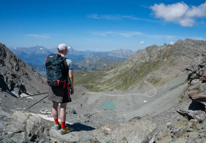 Senderismo en las majestuosas cordilleras del mundo, contemplando un lago turquesa y senderos serpenteantes.