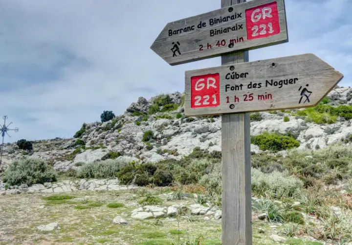 Señalización de ruta GR 221 en un sistema montañoso rocoso. Indica senderos a Barranc de Biniaraix y Cúber.