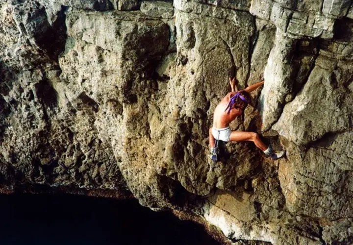 Patrick Edlinger, escalando en solitario una pared rocosa sobre el mar.