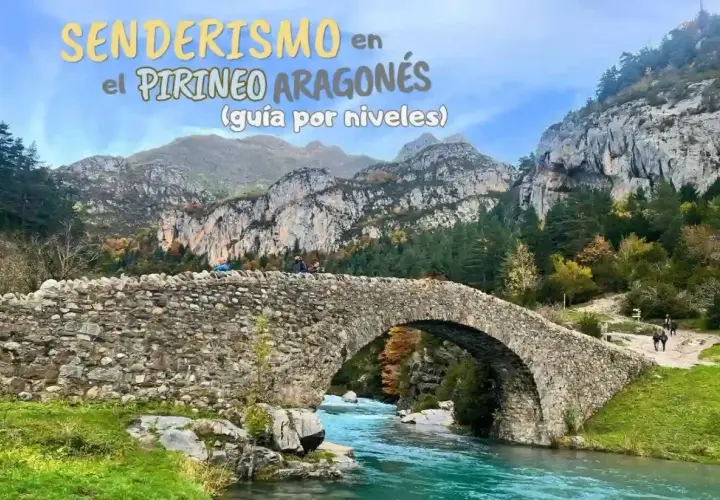 Puente de piedra sobre río turquesa en el Pirineo Aragonés, España. Senderismo entre montañas y bosques otoñales.