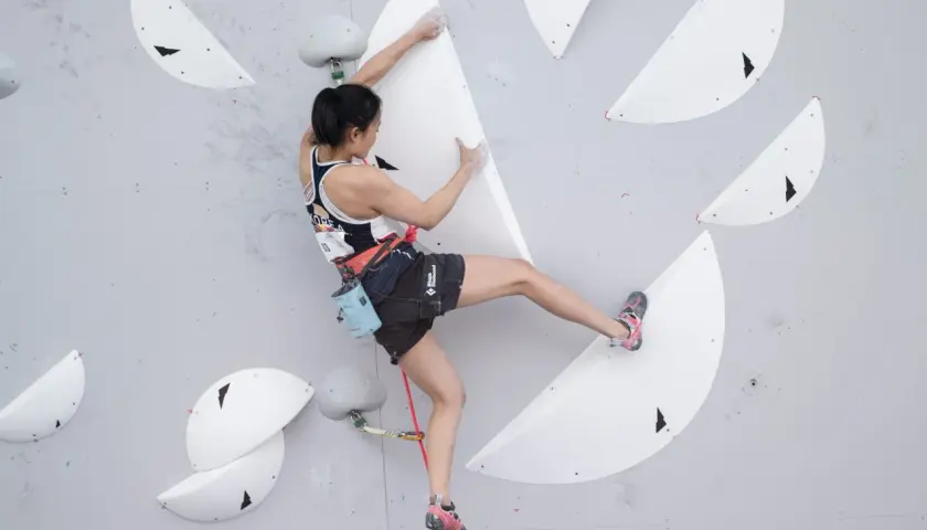 Brooke Raboutou escala una pared de búlder, concentrada en cada movimiento.