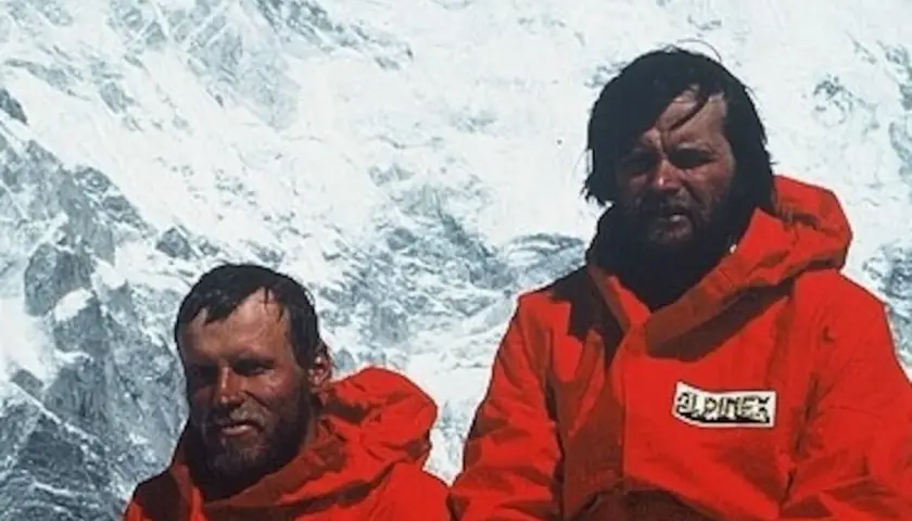 Maciej Berbeka y otro alpinista con chaquetas rojas en un paisaje nevado.