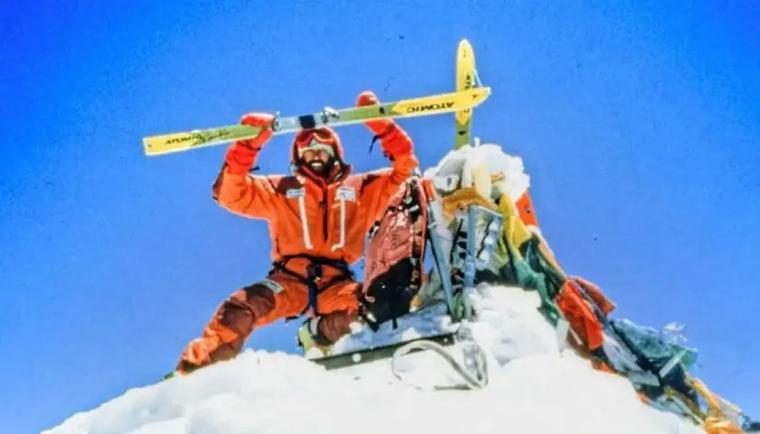Hans Kammerlander, con esquís, celebra en la cima nevada.