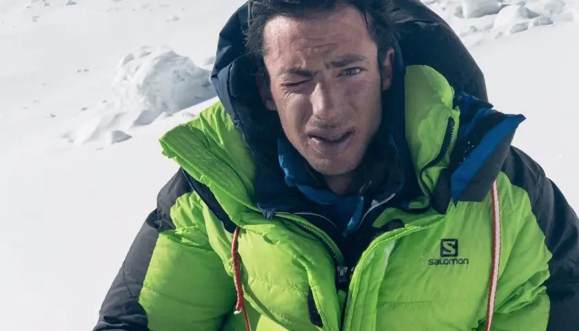 Kilian Jornet, con su chaqueta verde brillante, guiña un ojo en la cima del Everest.