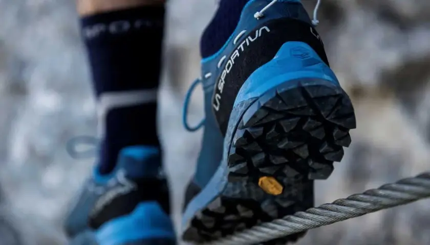 Persona cruza un cable con zapatillas de aproximación La Sportiva, ideales para terrenos difíciles.