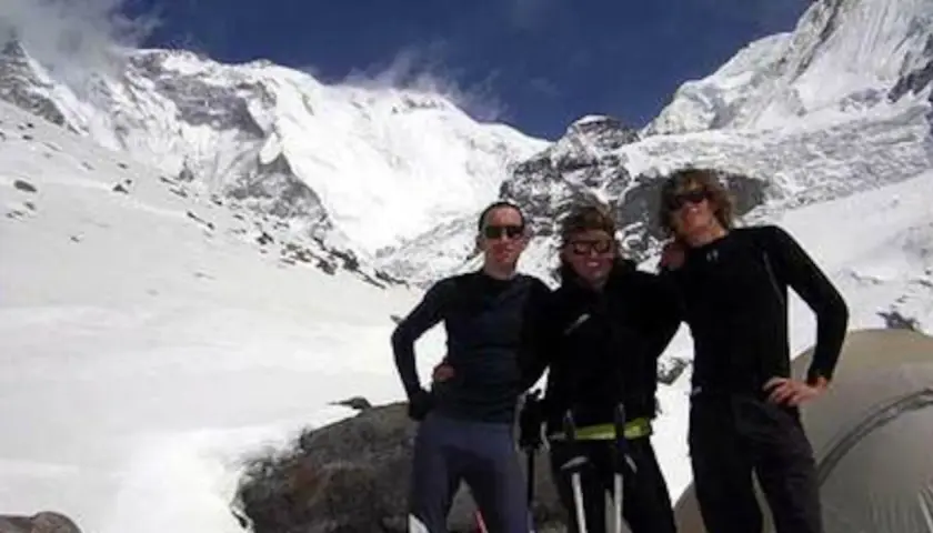Tres montañistas posan sonrientes ante un imponente pico nevado. Un recuerdo de expedición, antes del iñaki ochoa de olza fallecimiento.