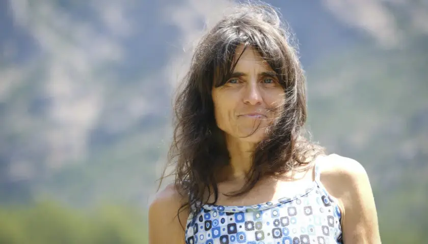 Silvia Vidal, con su cabello castaño al viento y una mirada serena, posa al aire libre con un vestido de estampado geométrico.