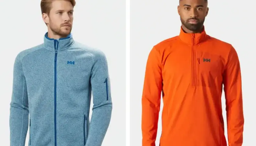 Dos hombres posan con chaquetas Helly Hansen. La de la izquierda es azul jaspeado con cremallera completa, ideal como capa intermedia. La de la derecha es naranja con media cremallera.