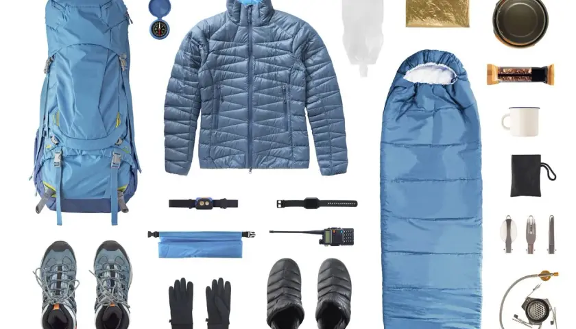 Equipo completo de **material alpinismo**: mochila, saco de dormir, chaqueta, botas, guantes, brújula, linterna frontal, radio, botiquín, taza, cubiertos y hornillo.