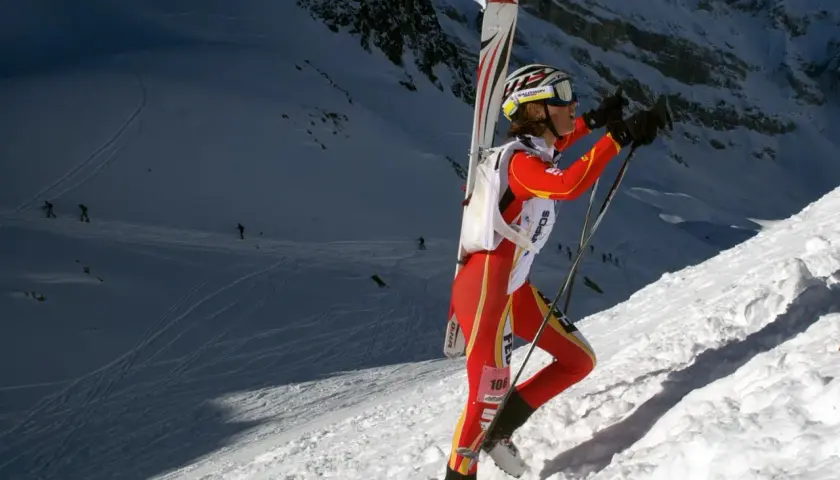 Mireia Miro, con esquís a la espalda, asciende una ladera nevada en una competición de esquí de montaña.