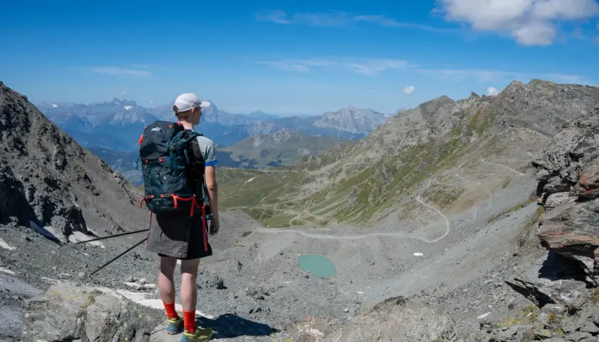 Senderismo en las majestuosas cordilleras del mundo, contemplando un lago turquesa y senderos serpenteantes.