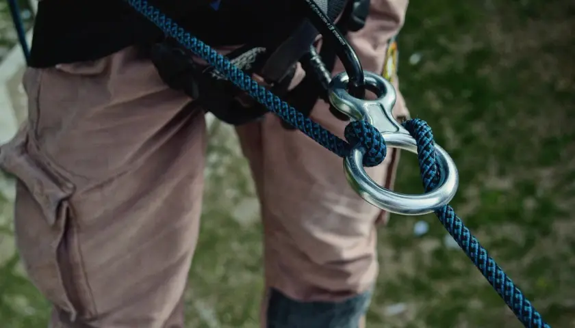 Detalle de equipo de escalada con varios tipos de cuerdas y mosquetones.