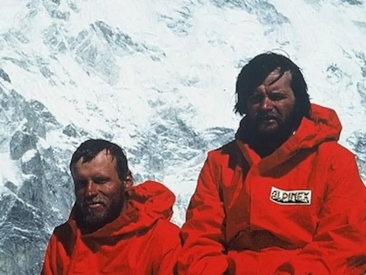 Maciej Berbeka y otro alpinista con chaquetas rojas en un paisaje nevado.