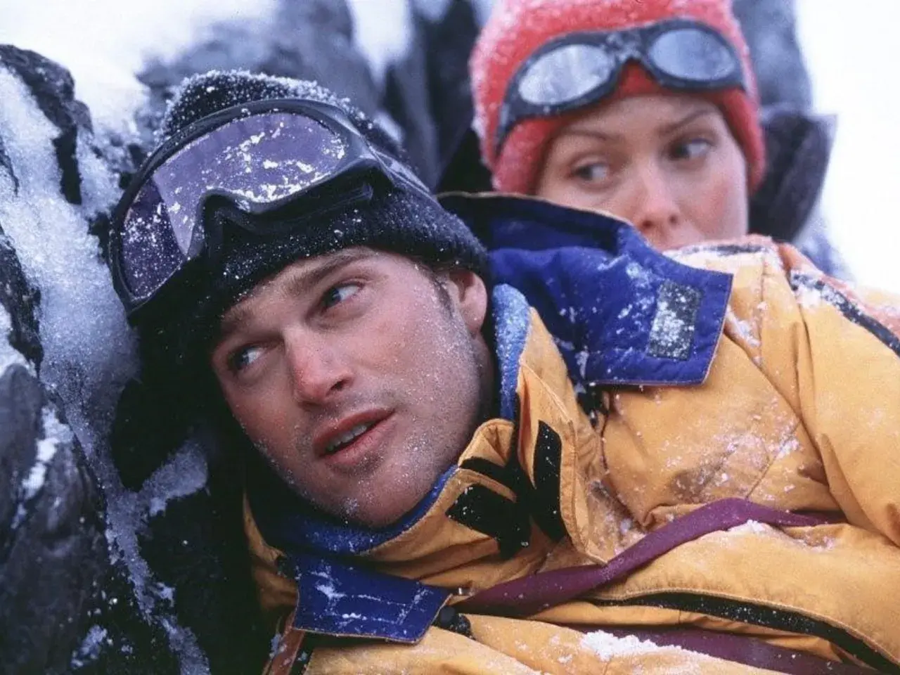 Dos escaladores, cubiertos de nieve, luchan contra el frío en una escena de una película de montaña.