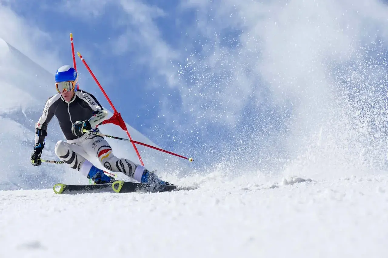 Esquiador compitiendo en slalom, mostrando la diferencia entre esquí alpino y de montaña en una pista nevada.
