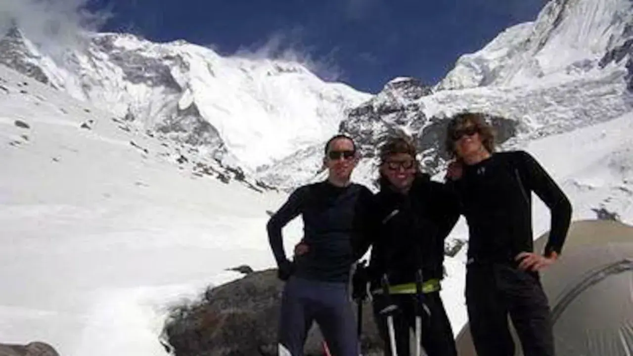Tres montañistas posan sonrientes ante un imponente pico nevado. Un recuerdo de expedición, antes del iñaki ochoa de olza fallecimiento.