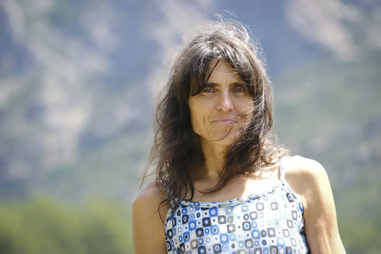 Silvia Vidal, con su cabello castaño al viento y una mirada serena, posa al aire libre con un vestido de estampado geométrico.