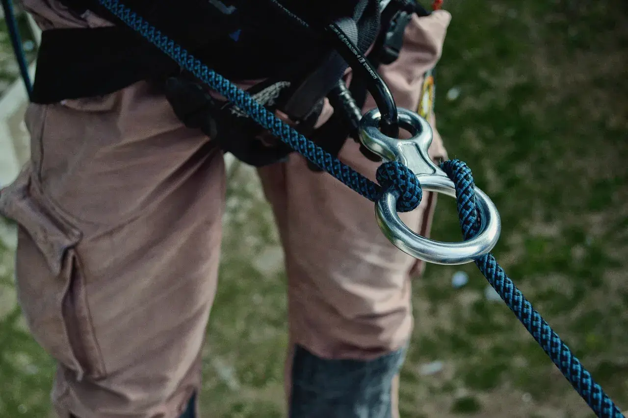 Detalle de equipo de escalada con varios tipos de cuerdas y mosquetones.