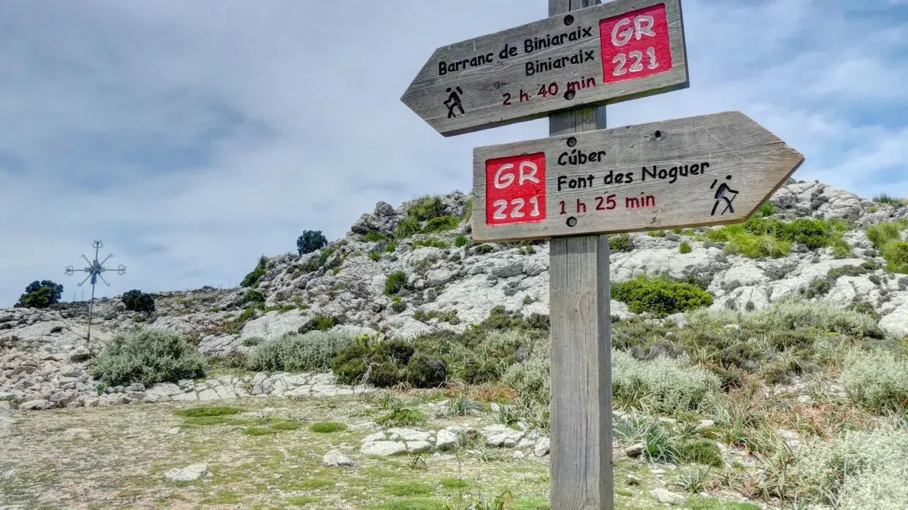 Señalización de ruta GR 221 en un sistema montañoso rocoso. Indica senderos a Barranc de Biniaraix y Cúber.