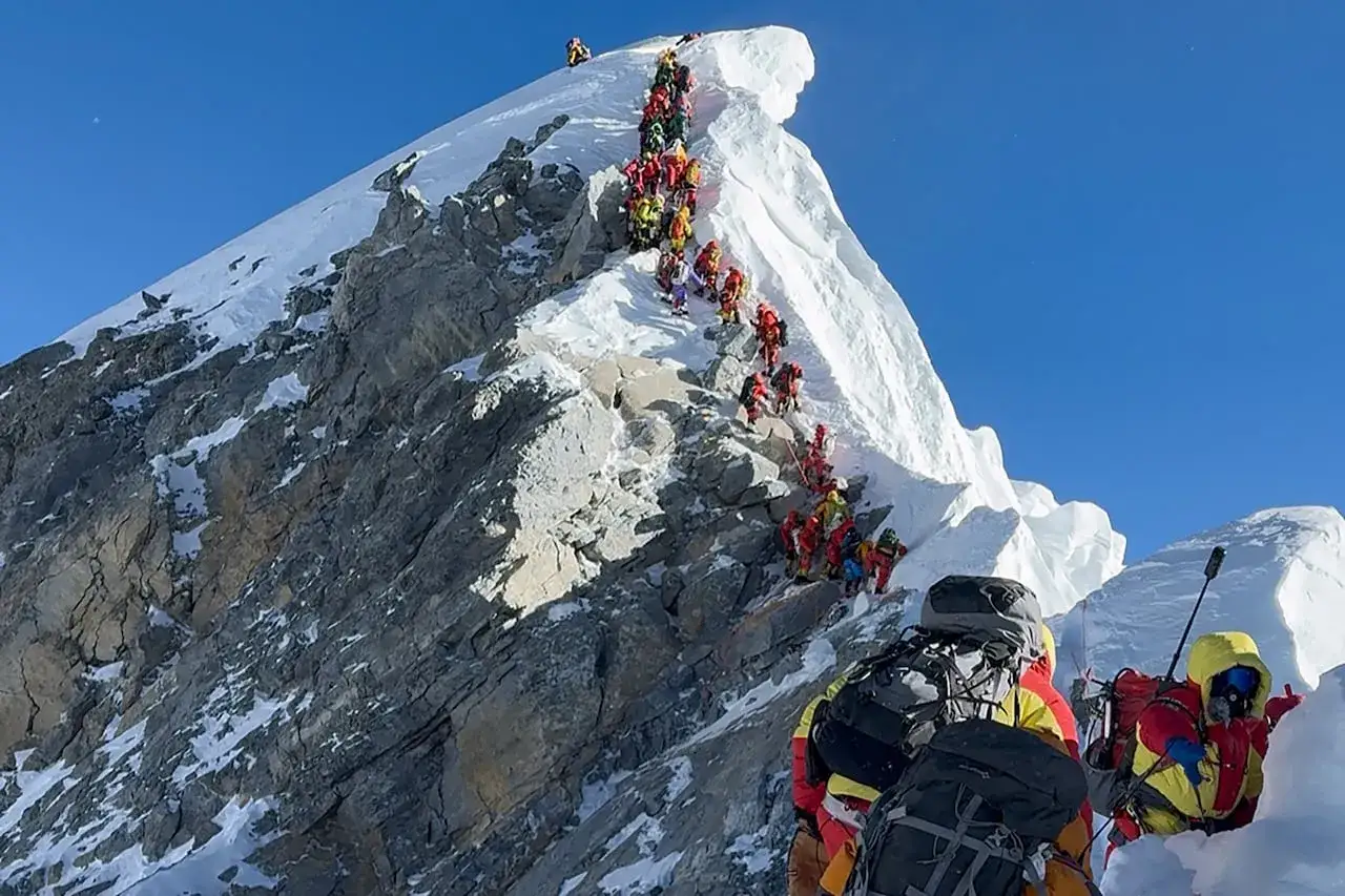 Una larga fila de alpinistas asciende por una cresta nevada del Everest. La expedición recuerda la valentía de Ueli Steck.