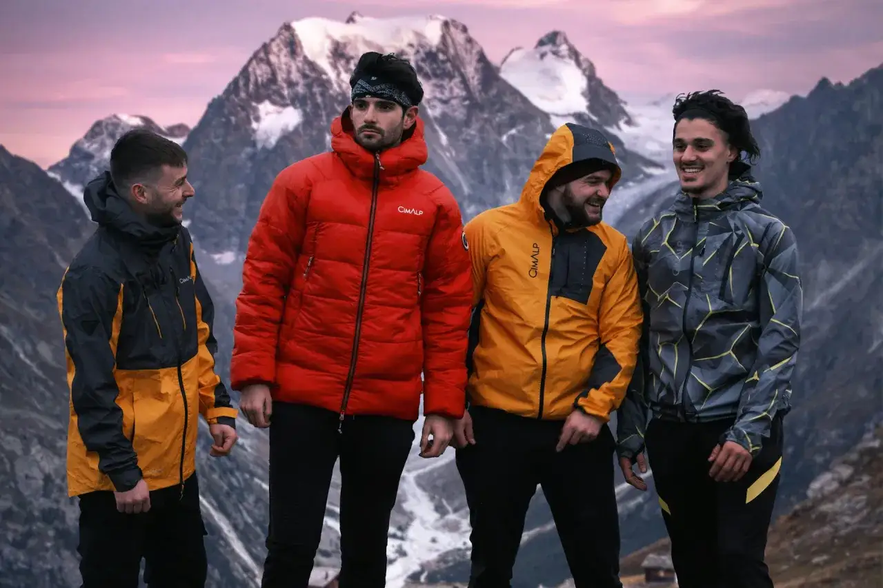 Cuatro amigos disfrutan de la montaña con chaquetas de poliamida que abrigan.