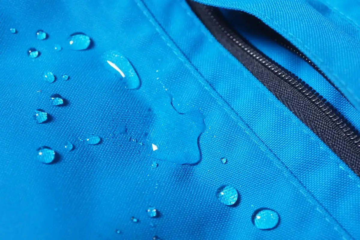 Gotas de agua sobre tela azul. La poliamida es transpirable, manteniendo la ropa seca y c&oacute;moda.