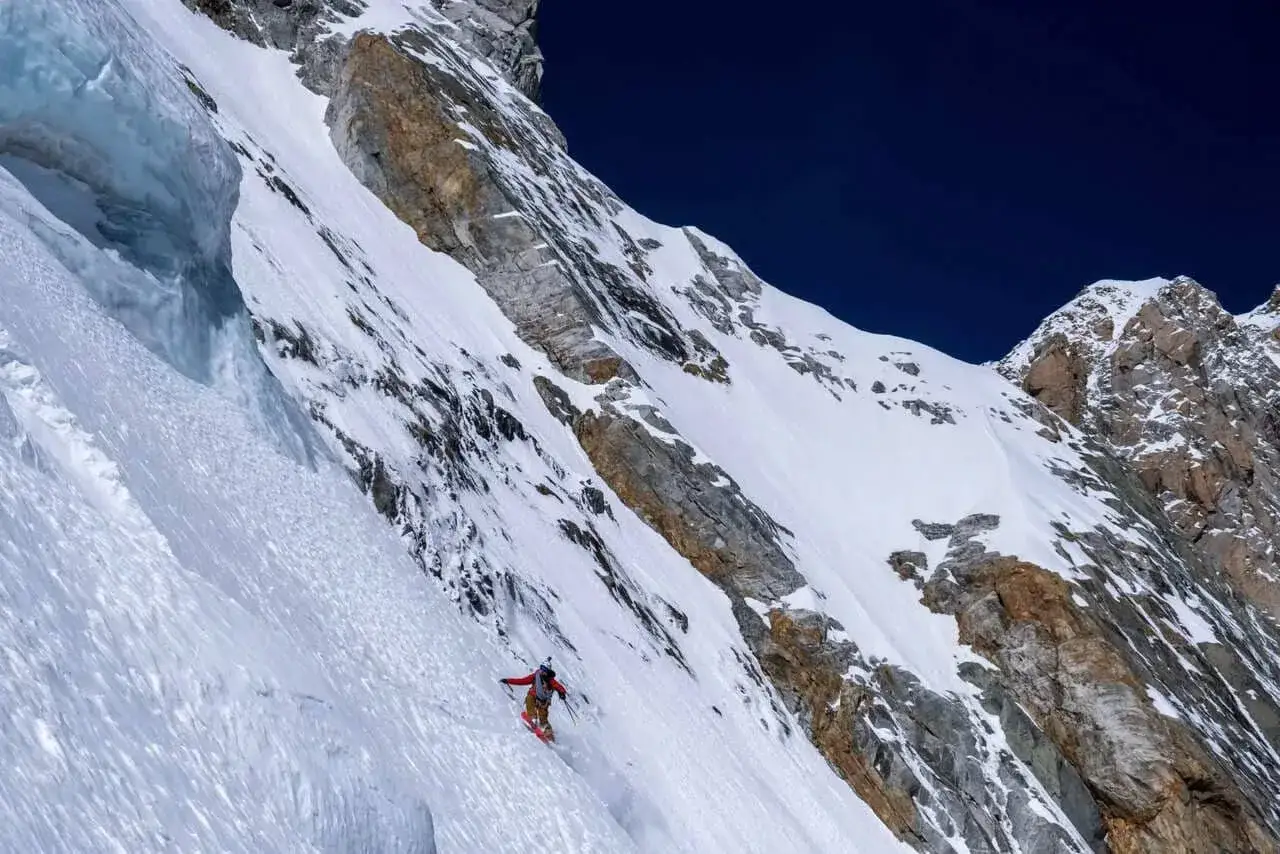 Vivian Bruchez desciende una ladera nevada y empinada, con rocas y hielo a su alrededor.