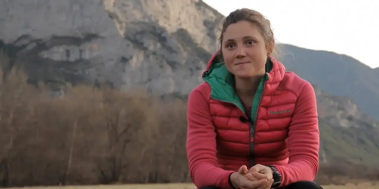 Mireia Miro, con chaqueta rosa, sonríe ante una montaña.
