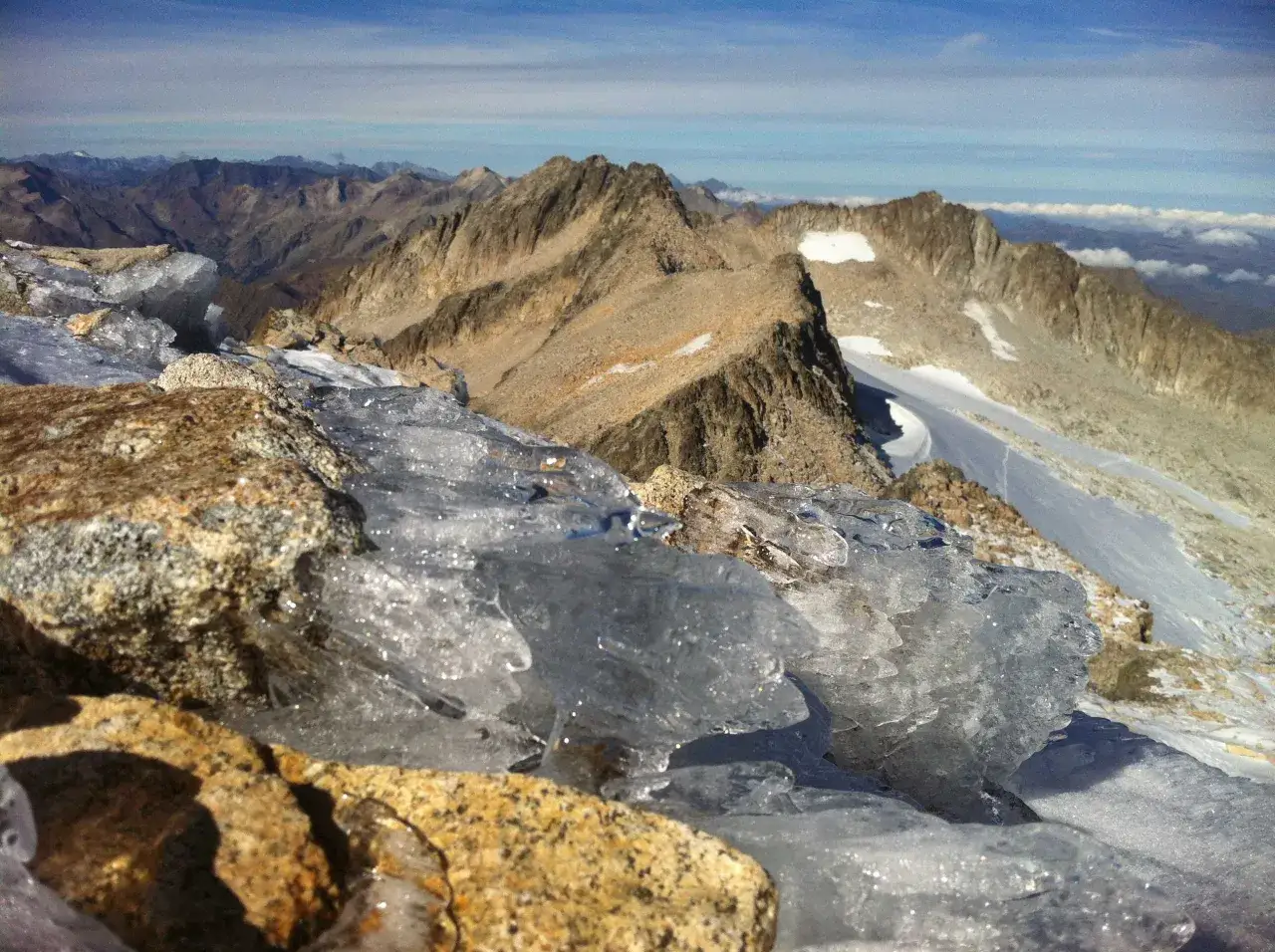 Rocas y hielo en primer plano, con picos montañosos y un glaciar al fondo, como si fueran coronas naturales.
