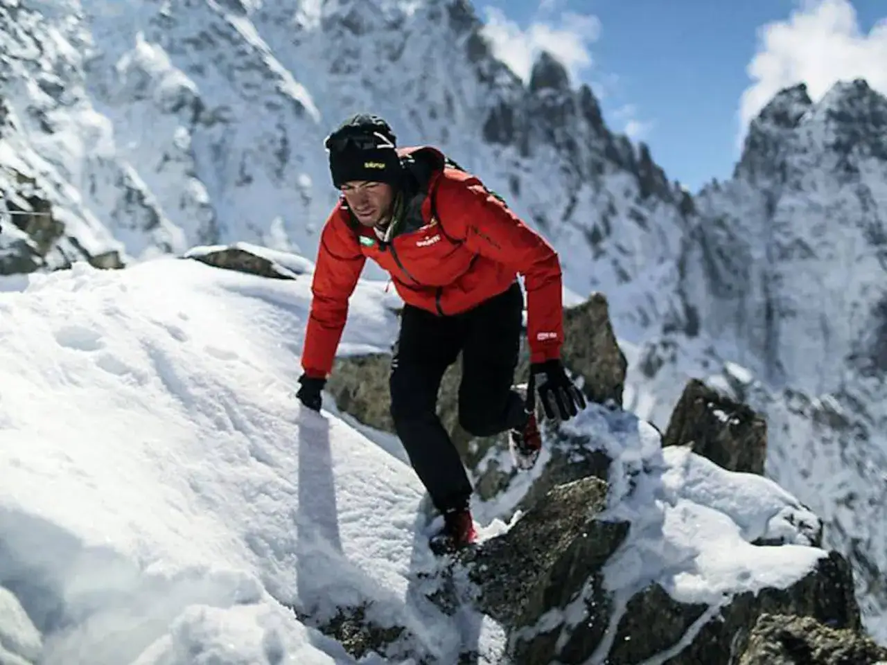 Kilian Jornet, con su chaqueta roja, asciende una montaña nevada, demostrando su increíble resistencia en busca de un nuevo récord.